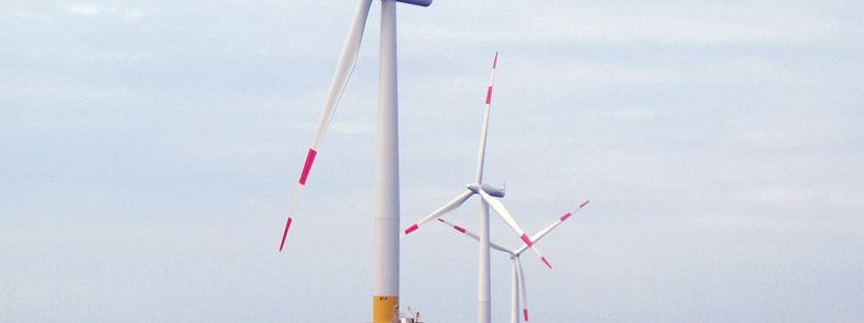 Three windmills at sea